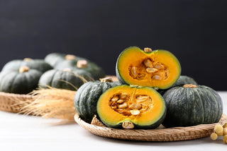 Image of whole and halved Kabocha winter squash with rich orange flesh, featured in Bloom Ranch of Acton's guide to the nutritional value and health benefits of Japanese pumpkin.